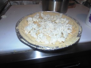 Breaking the goats cheese on the tart base for the Courgette, Saffron and Two Cheese Tart