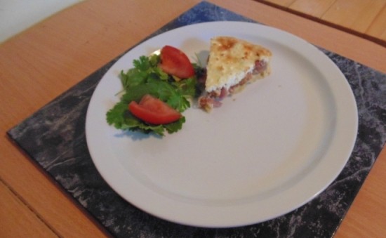 Graham’s Caramelised Red Onion and Goats Cheese Tart served a small side salad of herbs and tomato wedges